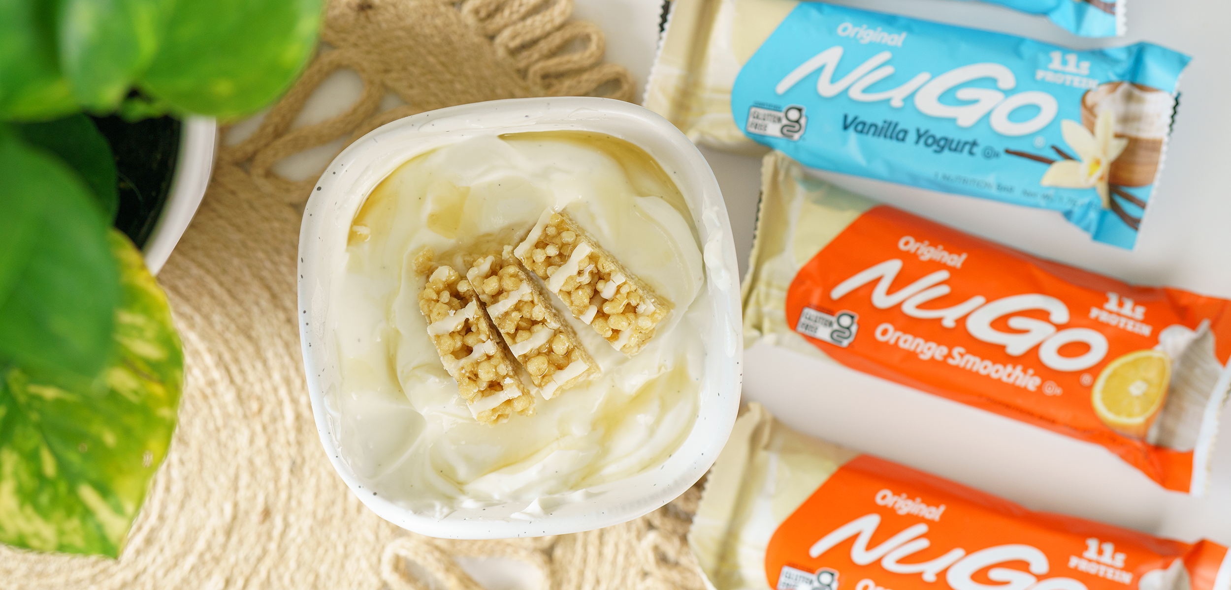 NuGo Original Vanilla Yogurt and Orange Smoothie next to cup of yogurt with cut bars on top