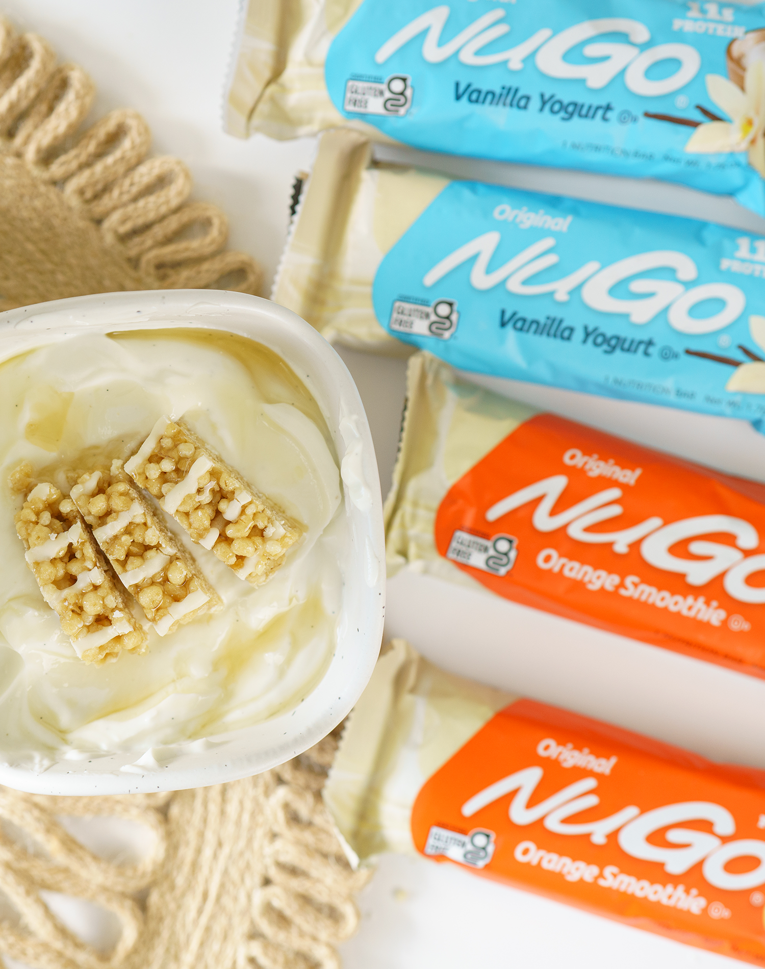 NuGo Original Vanilla Yogurt and Orange Smoothie next to cup of yogurt with cut bars on top