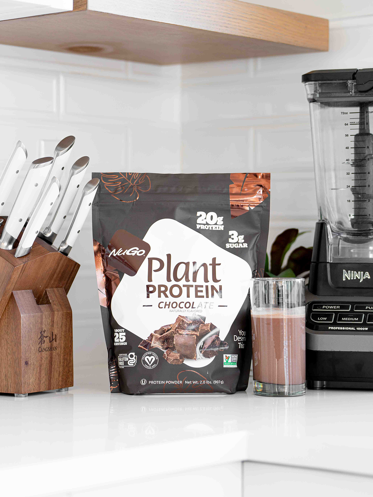 Bag of NUGo Protein Powder between a blender and a knife block