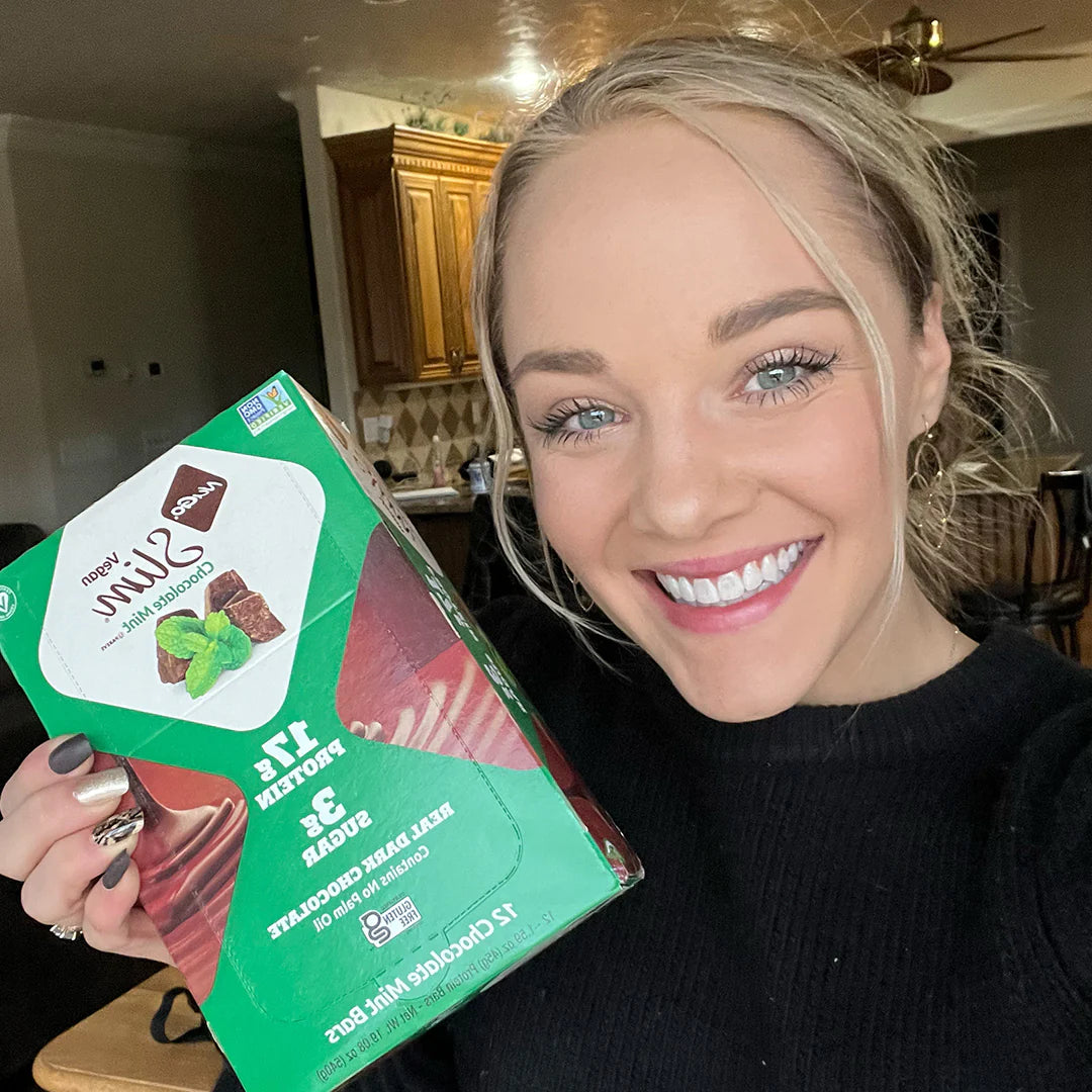 Woman holding a box of NuGo Slim Chocolate Mint next to face