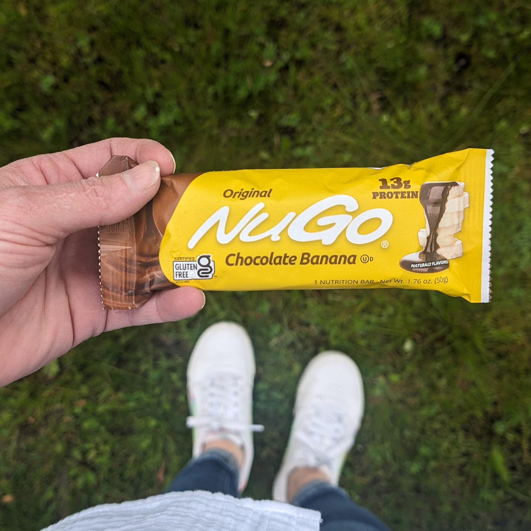 NuGo Original Chocolate Banana Bar held over grass