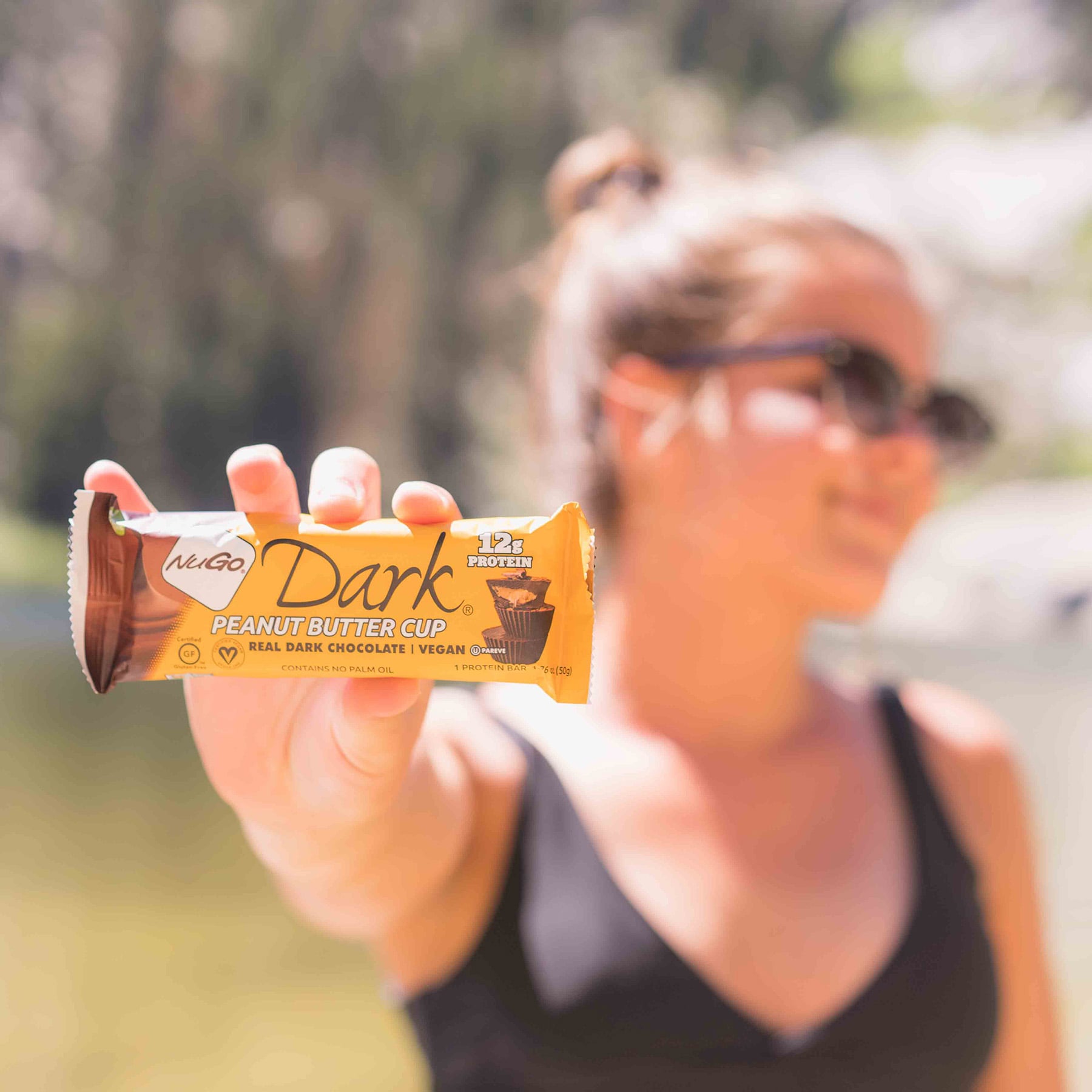 Close up of Peanut Butter Cup Bar with Woman in Sun glasses in backgrond