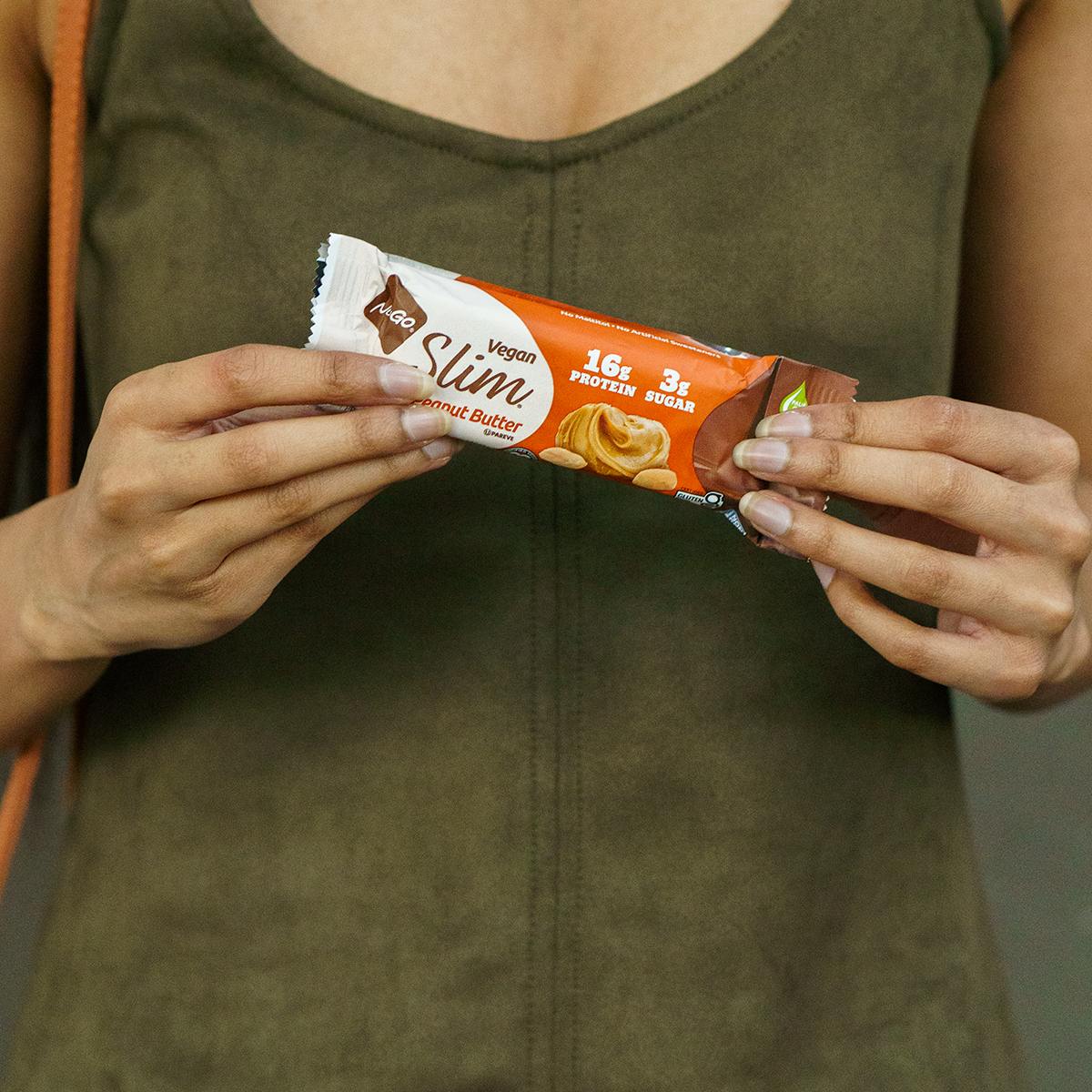 NuGo Slim Crunchy Peanut Butter Bar in front of Woman's body