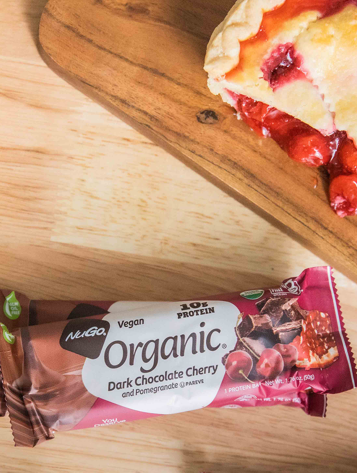 NuGo Organic Dark Chocoalte Cherry Pomegranate wrapped bar next to cherry pie
