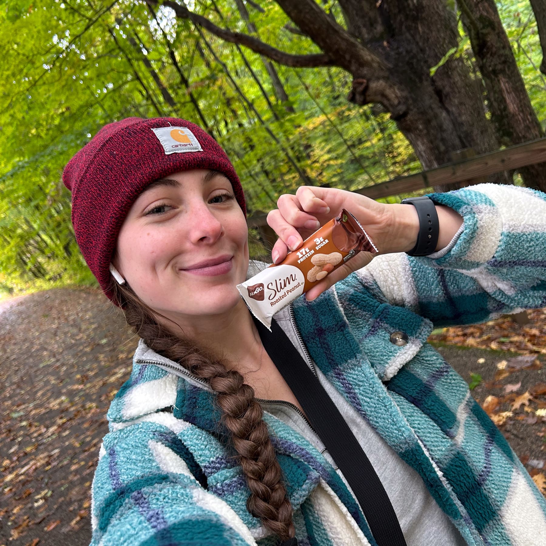 Woman in Woods with NuGo Slim Roasted Peanut bar